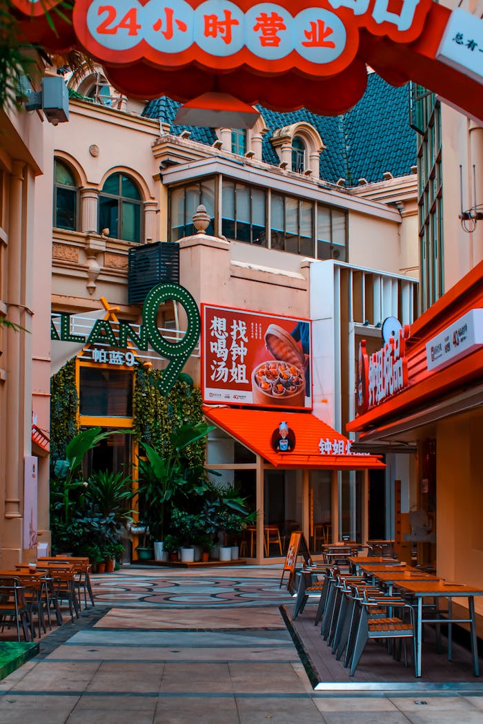 Vibrant alleyway featuring cafes and signage adorned with plants and decorative elements.