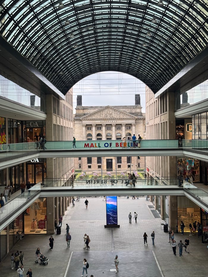 Services Spacious interior of Mall of Berlin showcasing a historical building through glass roof.